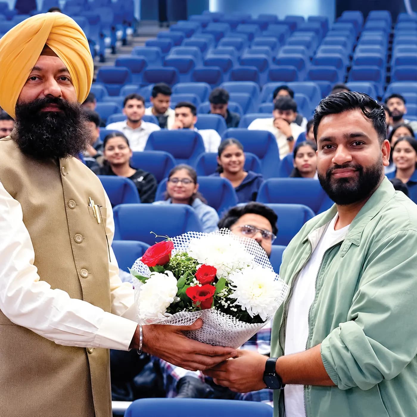 techcadd speaker welcomed with a bouquet in a college auditorium