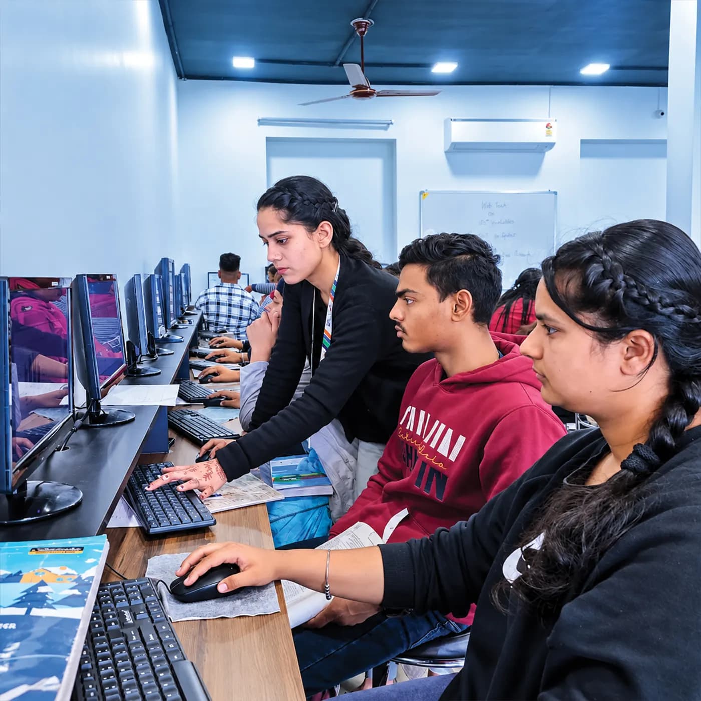 A trainer guiding a student at a computer