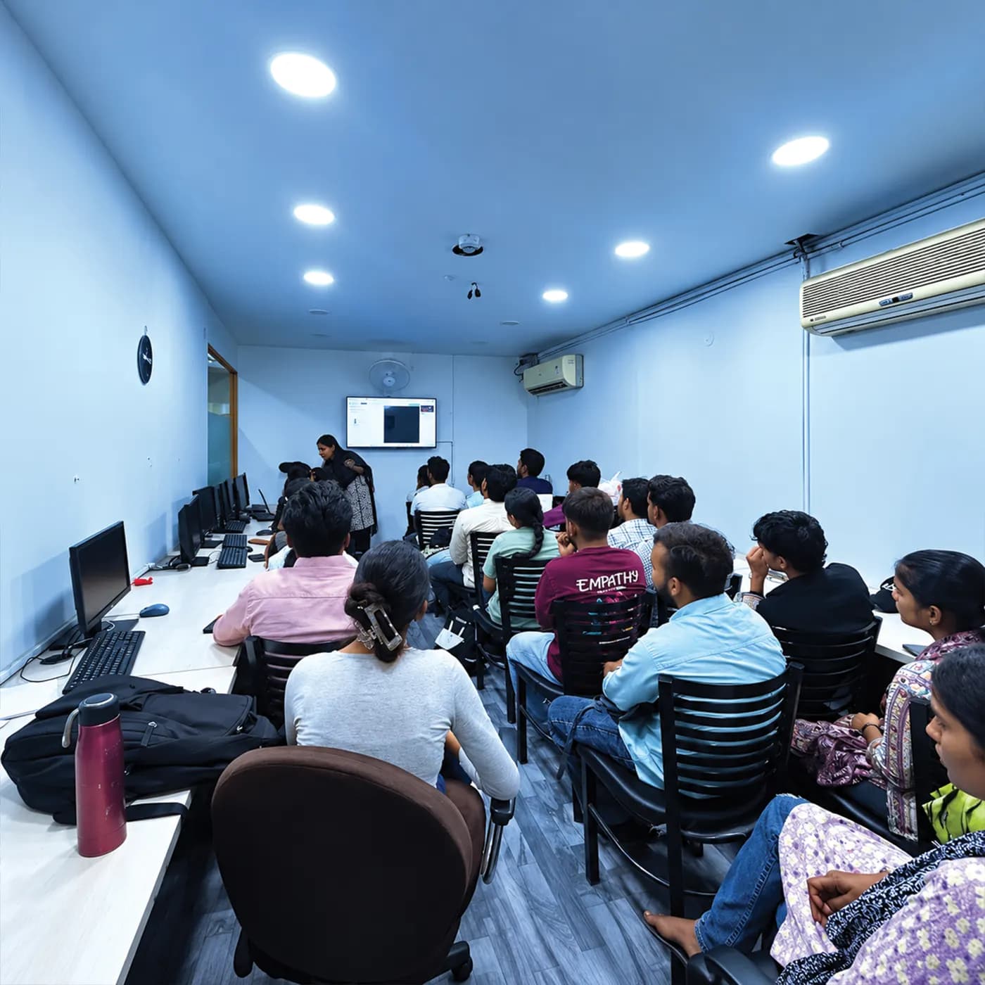 Students following a lecture on the classroom screen